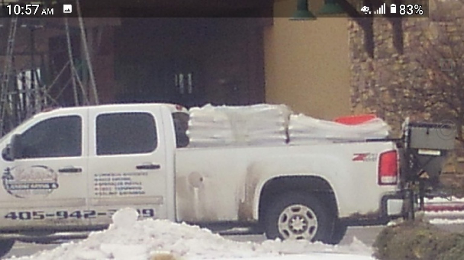 Brian’s company pickup loaded with bags and a rear spreader beside snow.
