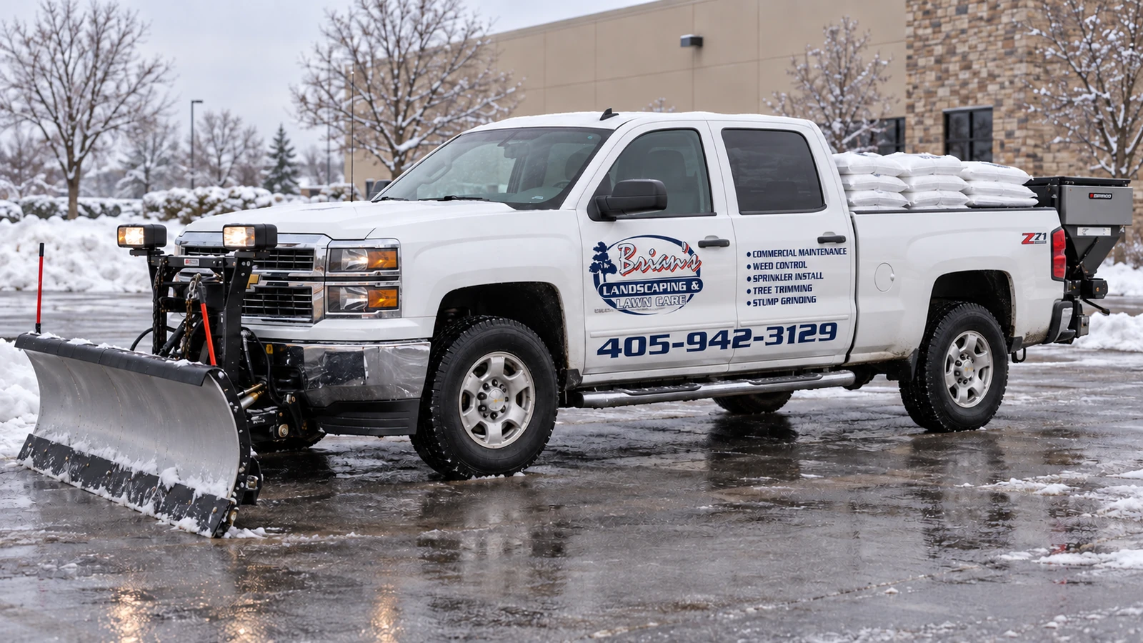 White older Chevrolet Silverado with navy-and-red Brian’s fleet lettering, a front snowplow, salt bags and a rear-mounted spreader in a snowy commercial parking area.